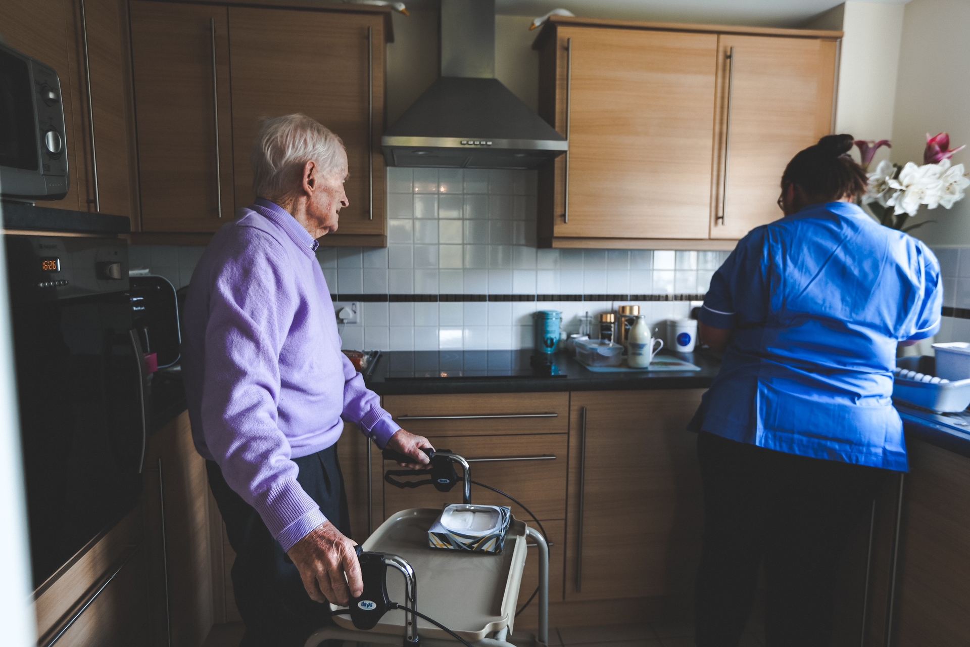 Tezlom care assistant supporting a lady at home in her kitchen